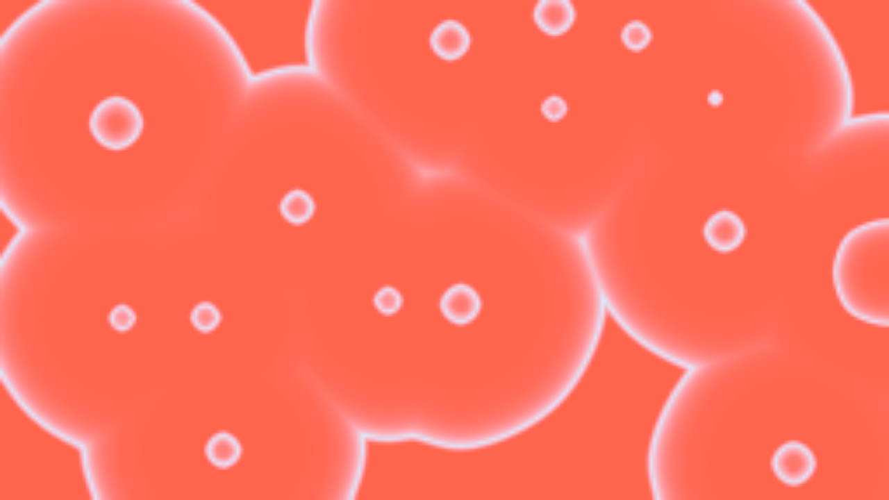 A ferroin Belousov–Zhabotinsky dish after fifteen minutes: pale blue oxidised rings spreading from pacemakers across a red reduced layer, meeting at cusps where they annihilate